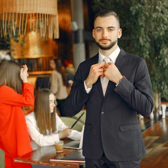 Man and two beautiful women working. People in a cafe. Women in a elegant suit cases